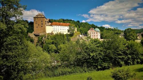 a group of buildings on a hill with trees at Rodinný pension Bečov in Bečov nad Teplou