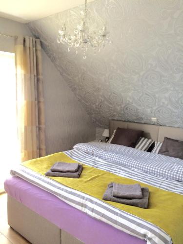 a bedroom with two beds and a chandelier at Ferienhaus Strandgut in Petersfeld