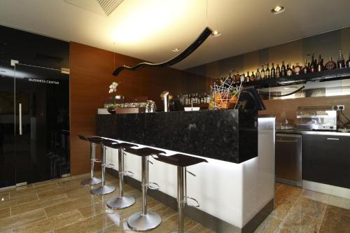 a bar with black granite countertops and bar stools at Mikado Hotel in Nitra