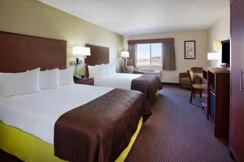 a hotel room with two beds and a television at AmericInn by Wyndham Osage in Osage