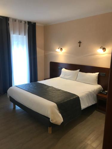 Postel nebo postele na pokoji v ubytování Hôtel Vesuvio