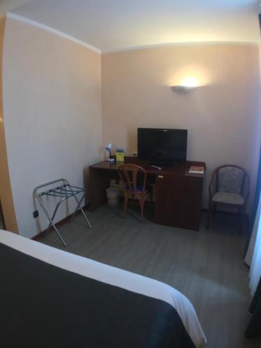Una televisión o centro de entretenimiento en Hôtel Vesuvio