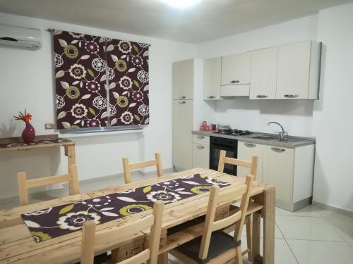 uma cozinha com uma mesa de madeira e uma cozinha com uma mesa e cadeiras em amendola24 em Cefalù