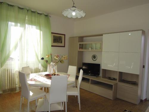 a dining room with a table and chairs and a television at Carpe Diem in Lierna