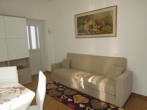 a living room with a couch and a painting on the wall at Carpe Diem in Lierna