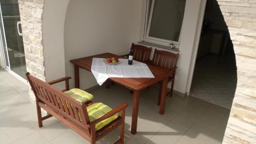 mesa y sillas en una habitación con mesa y ventana en Apartments Ante, en Vir
