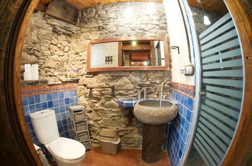 a stone bathroom with a sink and a toilet at Casa Independiente Rural Ca de Corral in Taüll