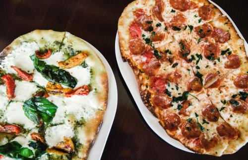 two pizzas sitting on plates on a table at The Chateaux Deer Valley in Park City