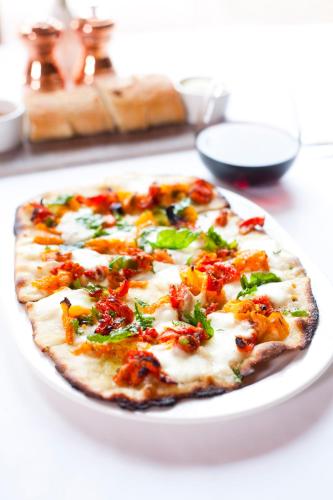 a pizza on a white plate on a table at The Chateaux Deer Valley in Park City