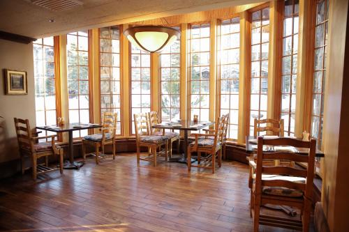 a dining room with tables and chairs and windows at The Chateaux Deer Valley in Park City