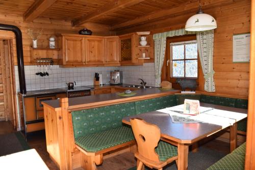 Untere Roner Kasa في Mörtschach: مطبخ مع طاولة وغرفة طعام