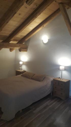 ブール・サン・モーリスにあるLe Chalet d'Augustaのベッドルーム1室(ベッド1台、テーブルにランプ2つ付)