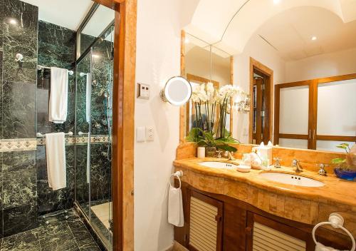 a bathroom with a sink, mirror and tub at Zoetry Villa Rolandi Isla Mujeres Cancun - All Inclusive in Isla Mujeres
