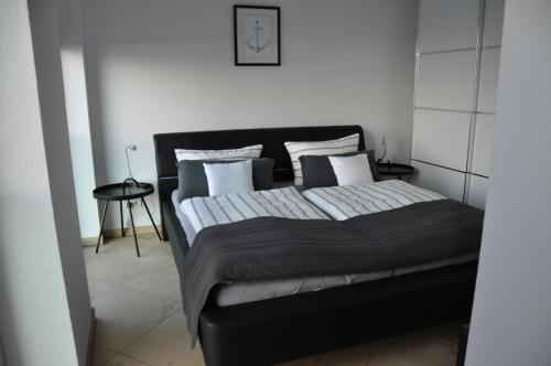 um quarto com uma cama grande e almofadas brancas em Am Neuen Hafen em Bremerhaven