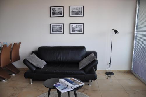 um sofá de couro preto e uma mesa numa sala de estar em Am Neuen Hafen em Bremerhaven