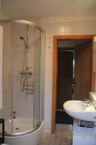 y baño con bañera, lavamanos y ducha. en Ferienhaus Puttrich, en Hohnstein