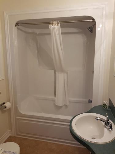 a bathroom with a shower and a sink at Covered Bridge Inn & Suites in Sussex
