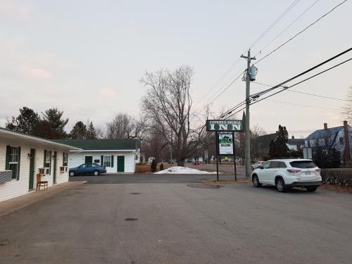 a street with a car parked in a parking lot at Covered Bridge Inn & Suites in Sussex