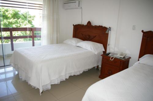 a bedroom with two beds and a phone on a night stand at Hotel Misional in Santa Cruz de la Sierra