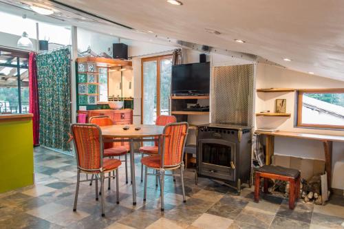 una cucina con tavolo, sedie e fornelli di Studio avec vue panoramique a Puget-Théniers
