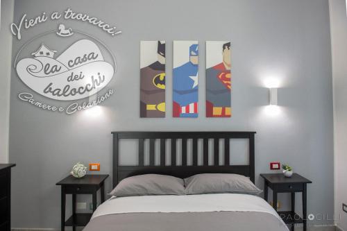 a bedroom with a bed and some pictures on the wall at La Casa dei Balocchi B&B in Toirano