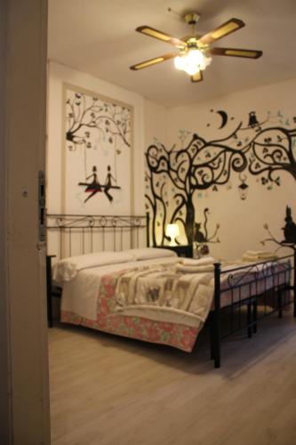 a bedroom with a bed with a tree mural on the wall at Al 68 Di Piazza Cavour in Naples