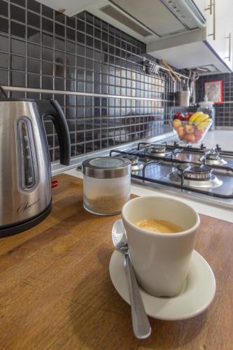 a cup of coffee sitting on a counter in a kitchen at Condomínio Ondas do Mar -Coastal Comfort- in Olhão