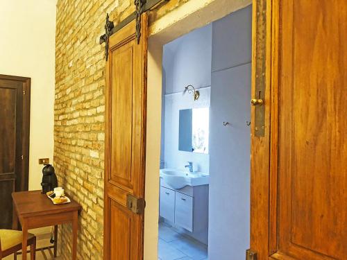 a bathroom with a sink and a brick wall at Charme of Villa Capannina in Novi Ligure