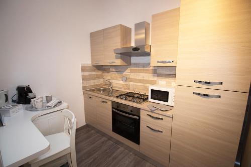 La cuisine est équipée de placards en bois et d'un four avec plaques de cuisson. dans l'établissement Lolly House 12, à La Spezia