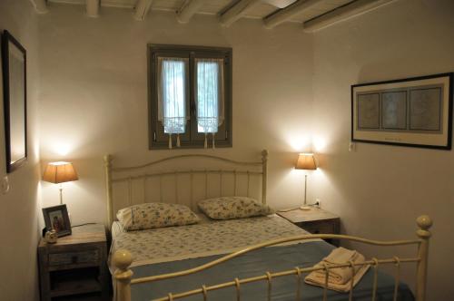 クリシ・アクティにあるElia's Oblivionのベッドルーム1室(ベッド1台、テーブル2台、ランプ2つ付)