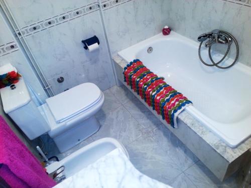 uma casa de banho com uma banheira branca e um WC. em Apartamento Sanxenxo - Playa Areas em Sanxenxo