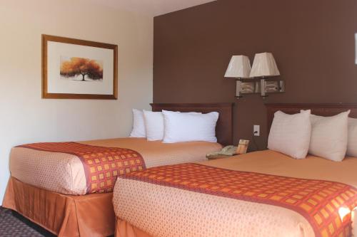 Habitación de hotel con 2 camas y una foto en la pared en Travel Inn Omaha, en Omaha