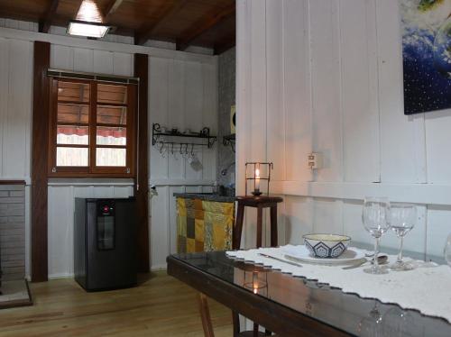 ein Zimmer mit einem Tisch mit Weingläsern darauf in der Unterkunft Cabana da Imperatriz in Santo Amaro da Imperatriz