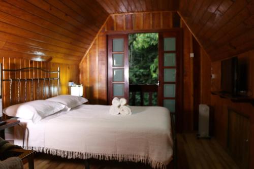 ein Schlafzimmer mit einem Bett mit einer weißen Schleife darauf in der Unterkunft Cabana da Imperatriz in Santo Amaro da Imperatriz