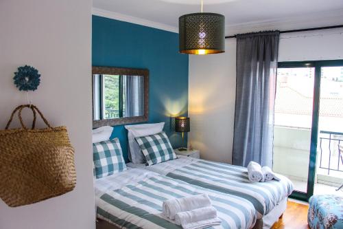 ファロにあるAlameda Gardenの青い壁のベッドルーム1室(ベッド2台付)