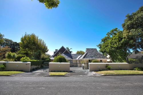 a house with a fence in front of a street at Villa Karibu in Tokai