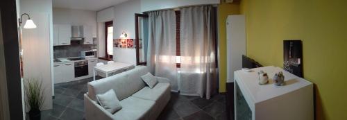 Casa Donatella في مالسيسيني: غرفة معيشة مع أريكة ومطبخ