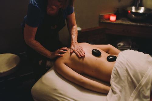 a woman getting a back massage from a man at El Colibri Hotel & Spa in Cambria
