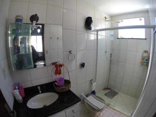 a bathroom with a sink and a toilet and a mirror at Rental Home Caminho do Mar Prainha in Arraial do Cabo