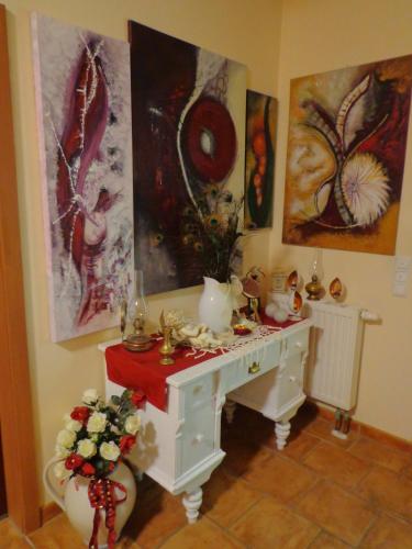 a white desk in a room with paintings on the wall at Apartment zum Wasserfall in Krakaudorf
