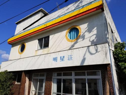 a building with a rainbow painted on the side of it at Minshuku Myojoso in Yoron