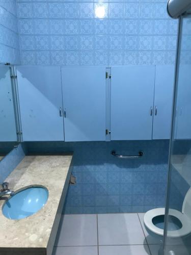 a bathroom with a sink and a toilet at Pousada Hostel Universitário in Londrina