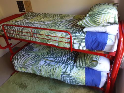 a red bunk bed in a room with at Murrays On Mary in Whangamata