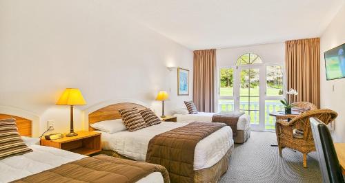 a hotel room with two beds and a window at Wallaceville Motor Lodge in Upper Hutt