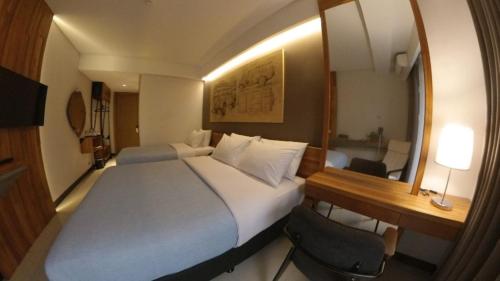 a bedroom with a large bed and a desk with a desk at Hay Bandung in Bandung