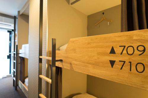a bunk bed in a room with a sign on it at Imano Tokyo Ginza Hostel in Tokyo