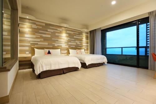 a bedroom with two beds and a large window at Seven Stars Sunrise,Seven Stars DEAR in Dahan