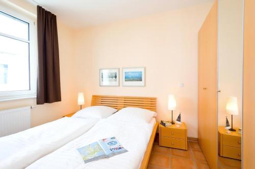 a bedroom with a white bed and a window at Villa Hildegard Appartement 2 in Binz