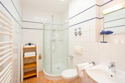 a bathroom with a shower and a toilet and a sink at Villa Hildegard Appartement 2 in Binz