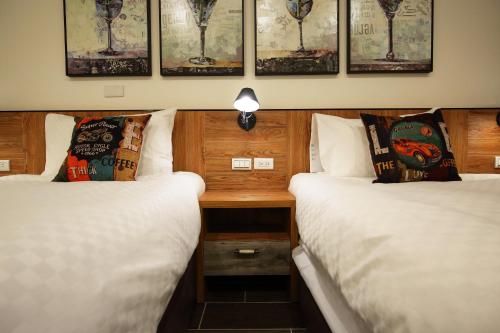two beds in a room with a desk between them at Seven Stars Sunrise,Seven Stars DEAR in Dahan